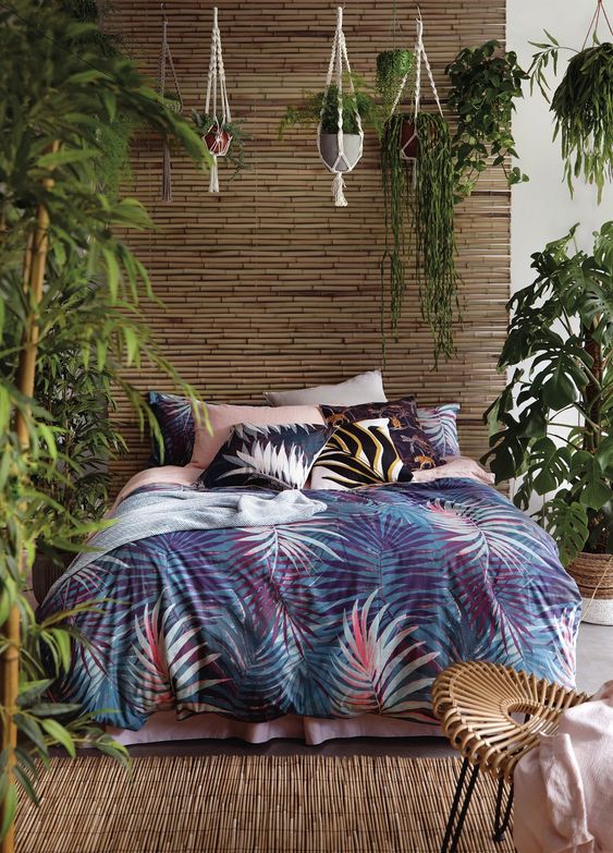 A-single-bamboo-wall-a-bamboo-rug-lots-of-potted-greenery-and-bright-tropical-bedding-create-an-ambience
