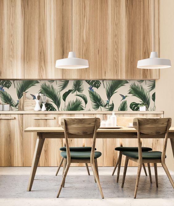 A-stylish-modern-kitchen-with-sleek-wooden-cabinets-a-tropical-leaf-backsplash-and-green-chairs-that-echo-with-it