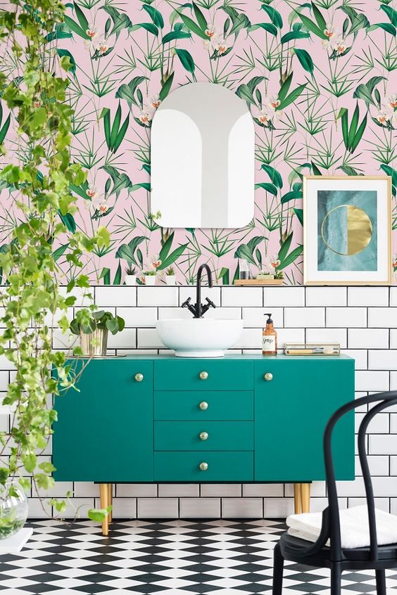 An-airy-and-fun-tropical-bathroom-with-catchy-wallpaper-a-green-vanity-cascading-greenery-and-touches-of-gold