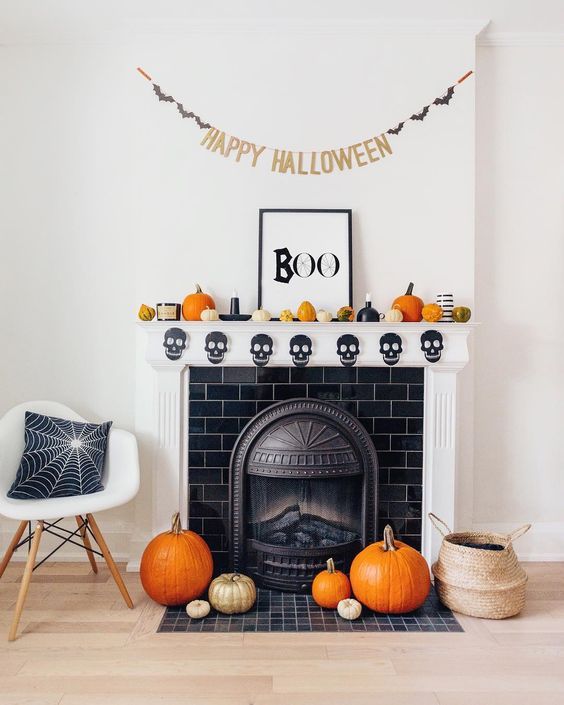 Fun-and-bright-halloween-mantel-decor-with-gourds-and-pumpkins-candles-a-banner-and-a-chic-sign-pumpkins-on-the-floor
