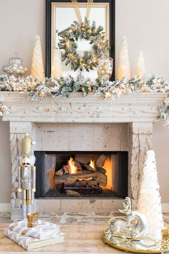 1 20-a-winter-wonderland-mantel-with-a-flocked-christmas-garland-a-wreath-with-lights-mini-christmas-trees-vintage-decor-and-silver-ornaments-in-a-jar