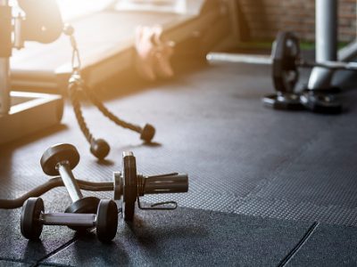 Gym background fitness weight equipment on empty dark floor
