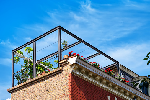 View from below on a outdoor terrace on the roof with plants and flowers