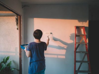 An asian chinese mid adult female painting her living room, apartment