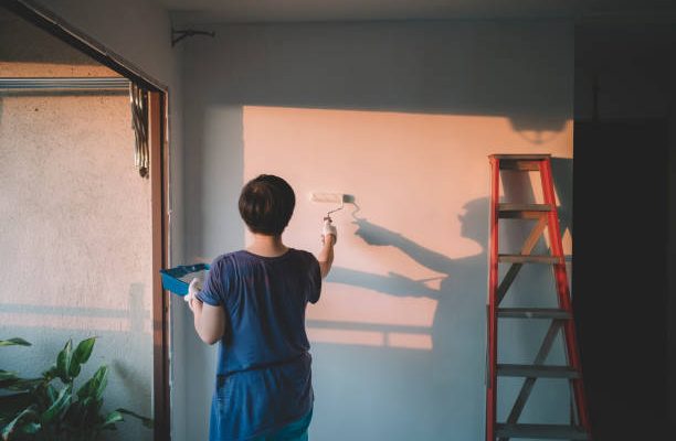 An asian chinese mid adult female painting her living room, apartment