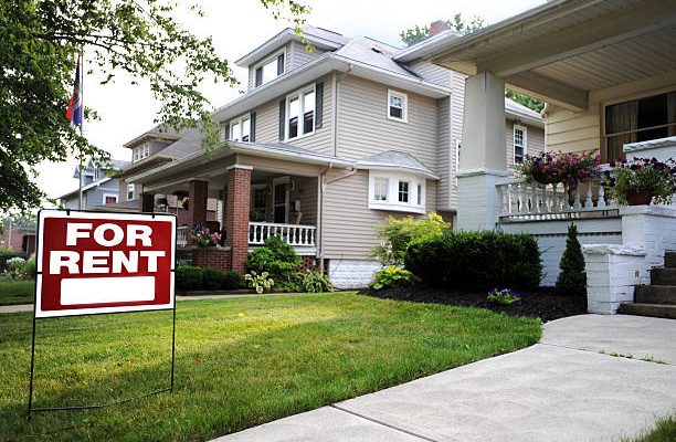 Home for rent sign in front of beautiful american home