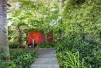 Tropical walkaway with red wall in the garden