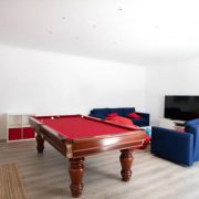 Living room with pool table and blue sofas