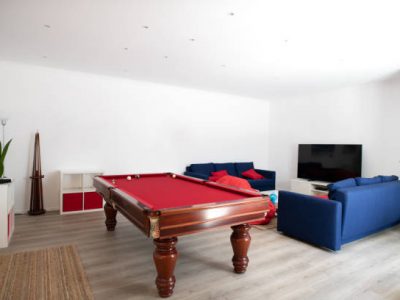 Living room with pool table and blue sofas