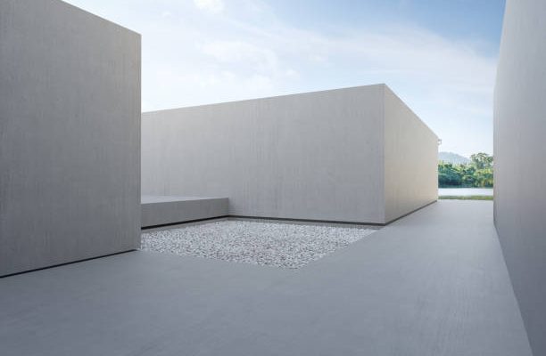 3d rendering of abstract gray building with lake and blue sky background.