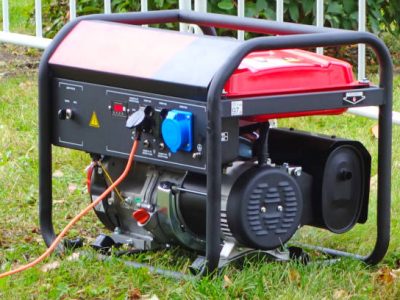 Working portable electric generator on green grass