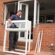 A window fitter removing old windows in preparation for new ones