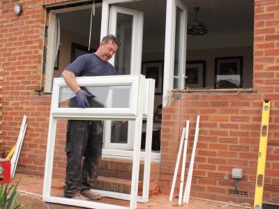 A window fitter removing old windows in preparation for new ones