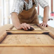 Carpenter work the wood with the sandpaper