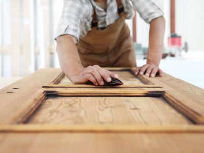 Carpenter work the wood with the sandpaper