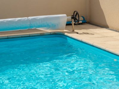 Closeup on a pool cover on the edge of a pool during the summer
