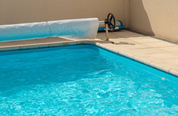 Closeup on a pool cover on the edge of a pool during the summer