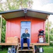 Young tourist traveler sits in front of cabin