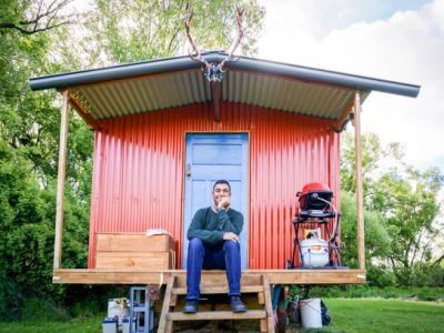 Young tourist traveler sits in front of cabin