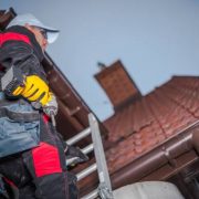 Caucasian roof worker with power tool. residential construction site.