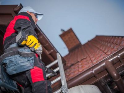 Caucasian roof worker with power tool. residential construction site.