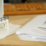 Silver pen lying at working table of architect with blueprints closeup