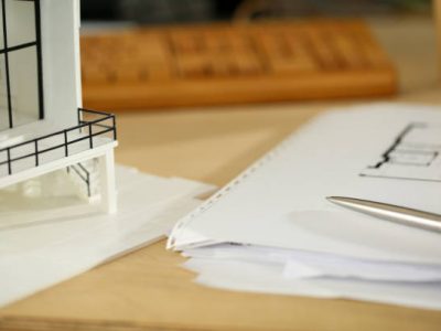 Silver pen lying at working table of architect with blueprints closeup