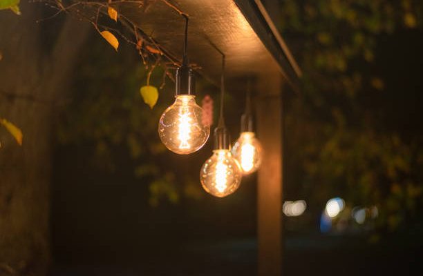 Electric incandescent light bulb street lamps glow brightly in the night park