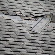 A badly damaged roof with missing shingles in need of repair