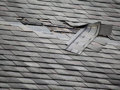 A badly damaged roof with missing shingles in need of repair