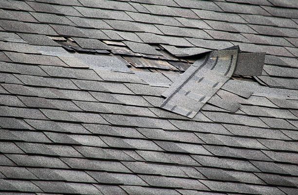A badly damaged roof with missing shingles in need of repair