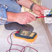 Electrician's hands assembles a standard bipolar wall socket.