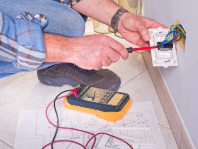 Electrician's hands assembles a standard bipolar wall socket.