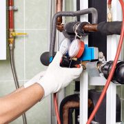 Maintenance engineer checking technical data of heating system.