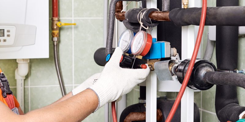 Maintenance engineer checking technical data of heating system.