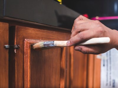 A handyman paints a fresh coat of varnish on the surface of a ba