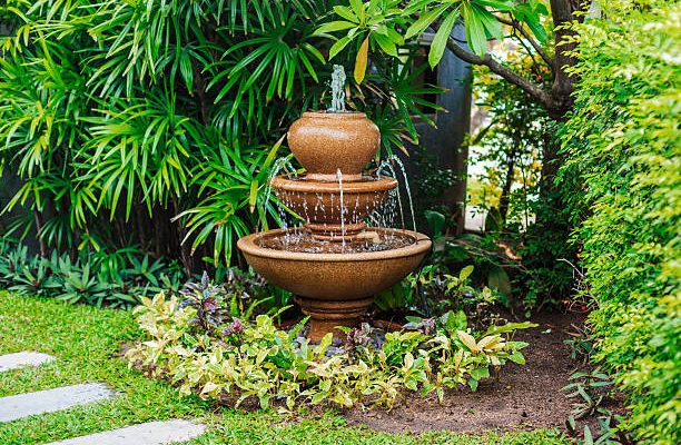 Fountain in green garden with walkway in thailand