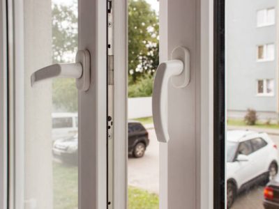 Handles of opened white plastic window indoor closeup