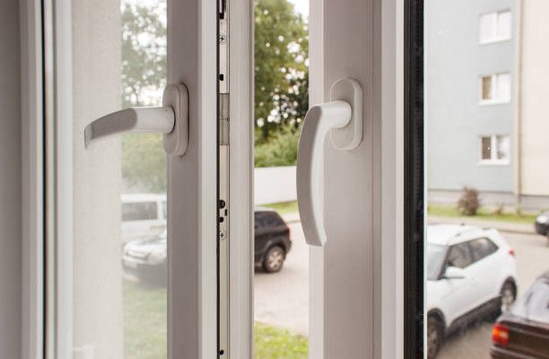 Handles of opened white plastic window indoor closeup