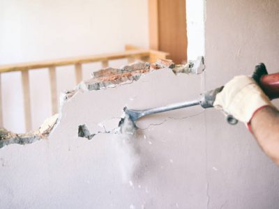 Construction worker using pneumatic hammer, construction site concept.