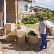 Movers carrying sofa from moving van to house