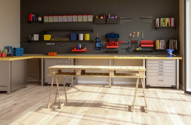 Workshop interior with tools, working equipments and wooden working table.