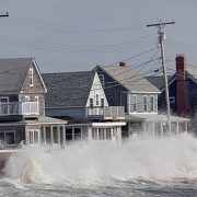 Waves crash against a break wall in conjunction with high tide and a storm.