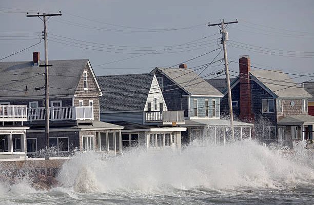 Waves crash against a break wall in conjunction with high tide and a storm.