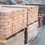 Pallets and packages of freshly produced red bricks in a construction warehouse on the street. concept of repair and building materials