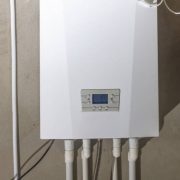 New gas boiler with gas meter hanging on the wall in the new house