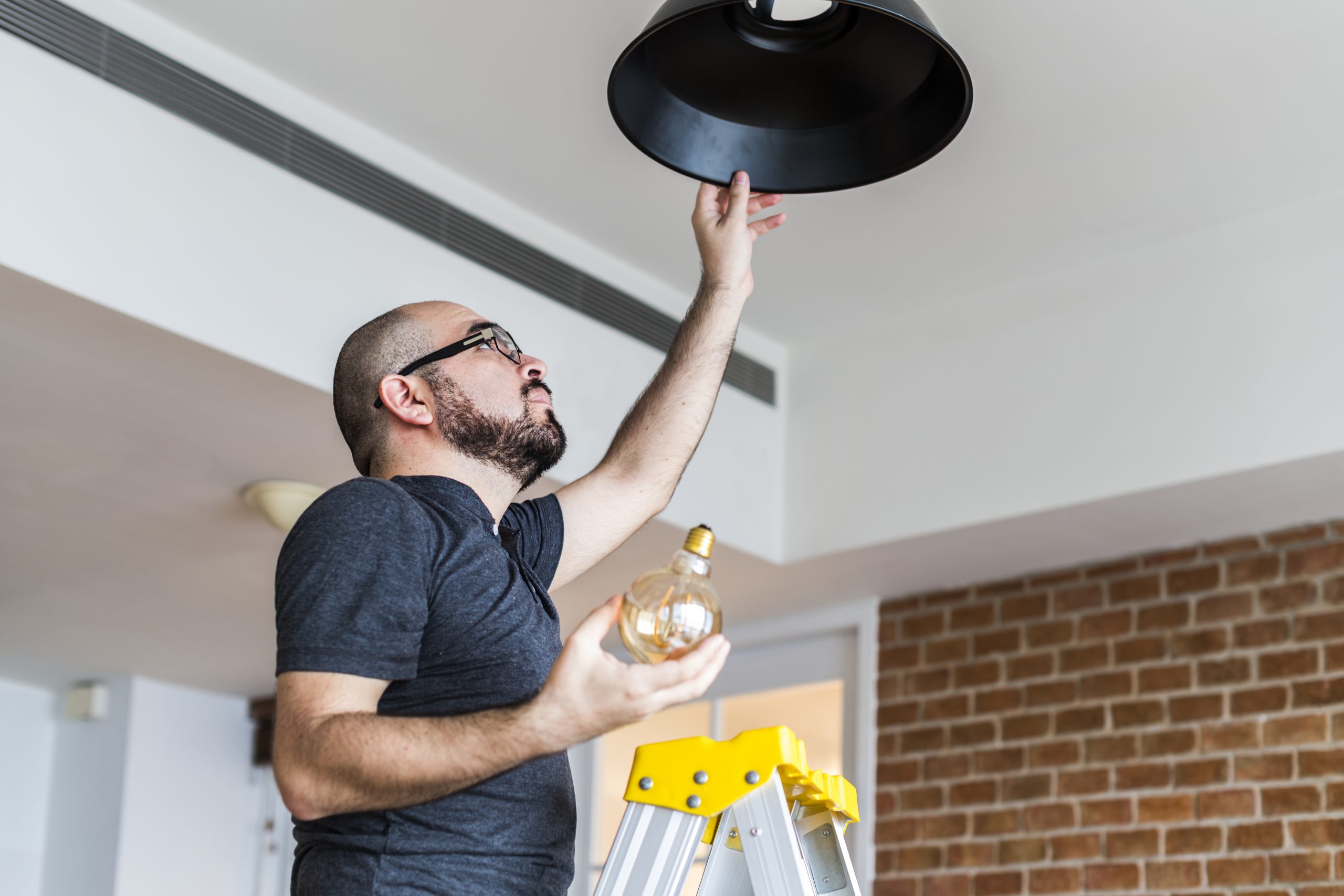 Man-changing-light-bulb