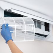 Technician cleaning air conditioner. hand holding air conditioning filter