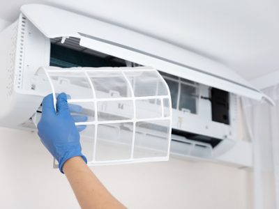 Technician cleaning air conditioner. hand holding air conditioning filter