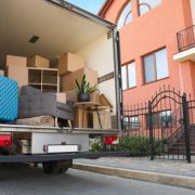 Van full of moving boxes and furniture near house